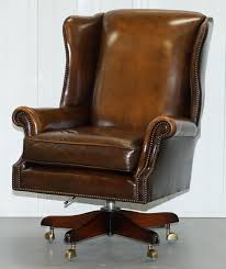 The wingback design is dotted with nailhead trim for a touch of texture and visual appeal, while fabric upholstery lends an inviting feel. Vintage Harrods London Oversized Brown Leather Wingback Office Captains Chair At 1stdibs