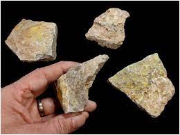 For example in the eu, council directive 2013/59/euratom sets the limit for uranium to $10^4$ bq (including the activity of its daughter nuclides). Radioactive Ore United Nuclear Scientific Equipment Supplies