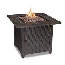 The fire pit has an antique bronze finish with a natural slate tabletop and a black base that holds a propane tank. Endless Summer 30 In W Bronze Finish Steel Base Faux Slate Mantel Lp Gas Fire Pit With Electronic Igition And Lava Rocks Gad1401m The Home Depot Gas Firepit Gas Fire Pits