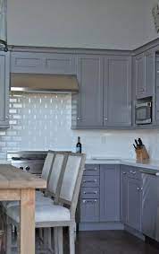 Blue subway backsplash tiles lined with white grout complement white shaker kitchen cabinets topped with a gray polished marble countertop fitted with a chrome faucet fixed beneath cabinets and over stainless steel sink. Gray Cabinets Transitional Kitchen William Adams Design Shaker Style Kitchen Cabinets Kitchen Cabinet Styles Kitchen Tiles Design