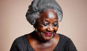 Portrait video of a pleased 100-year-old elderly Nigerian black woman  wearing a chic cardigan against a pastel or soft colors background
