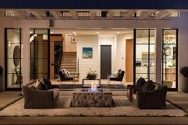 Modern Farmhouse Backyard With Black Windows And Stone Firepit Backyard Firepit Fire Pit Seating Area Stone Fire Pit Rustic Fire Pits