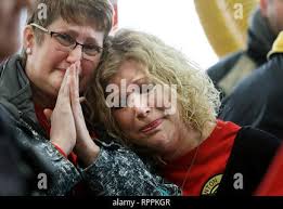 Clinton, Iowa, USA. 25th Jan, 2019. Clinton, Iowa Fire Department Lt. Ed  Wing rubs firefighter Adam Cain's head during a homecoming celebration for  Cain who was seriously injured while battling a grain