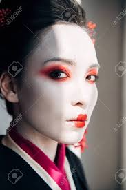 Portrait De La Belle Geisha Avec Du Maquillage Rouge Et Blanc Regardant La  Caméra Au Soleil Banque D'Images et Photos Libres De Droits. Image 128144842