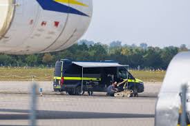 A German flag waving in front of the Leipzig-Halle Airport facility following security concerns regarding explosive-laden drones.