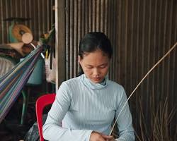 Hands of a Cambodian artisan intricately weaving a basket