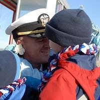 Cmdr. Dave Stoner holds his granddaughter for the first time during the  ship's return to Naval Station Norfolk.