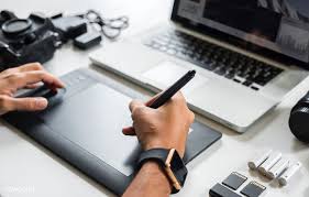 Download Premium Image Of Graphic Designer Working With A Laptop And A Graphic Design Digital Drawing Tablet Tablet