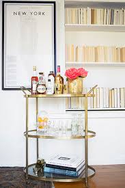 White marble and dark walnut bar serving cart. West Elm Gold Framed Mirrored Bar Cart Copycatchic