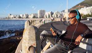 Junge Gemischte Rasse Mann Auswahl Musik Playlist Auf Seinem Handy Handy Geniessen Den Sonnenuntergang Entlang Des Ozeans Lizenzfreie Fotos Bilder Und Stock Fotografie Image 84882342