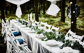 Eine Hochzeitstafel Im Wald Mit Weisser Tischplatte Spitzengardinen Als Tischdecken Weissen Klappstuhlen We Hochzeitstisch Tisch Dekorieren Hochzeitstischdeko