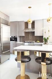 It features a large floral design made from iron in hues of teal and blue with gold highlights. Modern Kitchen With Gold Accents Luxe Interiors Design