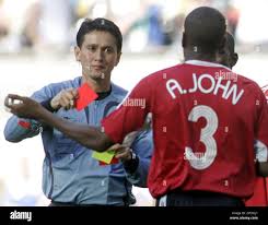 FILE ** Trinidad and Tobago's Avery John, right, receives a red card by  umpire Shamsul Maidin of Singapore, after fouling Sweden's Christian  Wilhelmsson, not shown, during the Sweden v Trinidad and