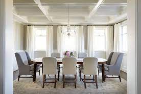 For a traditional setup, place chairs that include arms at the head and foot of the table. Oval Dining Table With White And Gray Dining Chairs Transitional Dining Room