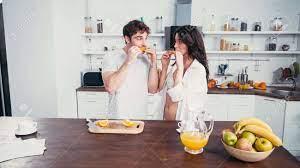 Young Man And Sexy Woman In Bra And Shirt Eating Ripe Orange In Kitchen  Stock Photo, Picture And Royalty Free Image. Image 171584159.