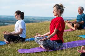 Morning yoga is a mental and physical practice where postures are combined with breathing morning yoga is very beneficial. Group Of Women And Men Taking Part In A Yoga Class On A Hillside Stockphoto