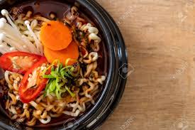 The signature fiery red broth, the yellowish bouncy noodles bobbing beneath . Korean Instant Noodles In Black Bowl Korean Food Style Stock Photo Picture And Royalty Free Image Image 127774935