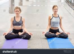 Two Beautiful Sport Women Doing Yoga Asana On Mat In Urban City Outdoors Group Of Female People Wearing How To Do Yoga Sports Women Fitness Healthy Lifestyle
