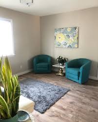Delicate shades of gray paint color used throughout, from the walls to the sofa set, make this living room look extra spacious. Color Smith Blog