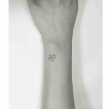 Tiny Black Heart Tattoo On The Right Outer Wrist With A Word Tiny Heart Tattoos Black Heart Tattoo Heart Tattoo