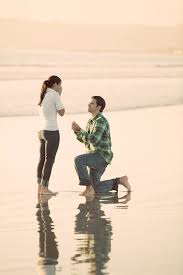 The Message Behind A Man Kneeling On One Knee To Propose Is The Offering Of Himself Wholeheartedly To The Wo Beach Proposal Surprise Proposal Wedding Proposals