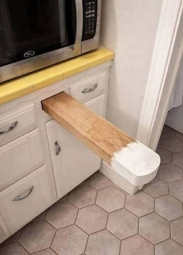 What is the purpose of the small shelf next to the kitchen island?