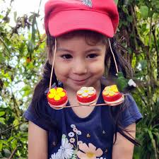 Lending a hummingbird hat feeder to a young girl in Ecuador