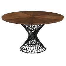 It's crafted from solid wood, with either an oak or walnut wood grain tone, and has a rounded surface set on four oval legs. Cairns Modern 54 In Round Walnut Dining Table Eurway