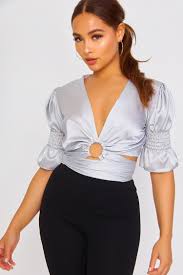 Femme en haut décolleté plongeant noir tenant son bras. Top Gris Satine A Nouer Decollete Plongeant Brentiny Paris