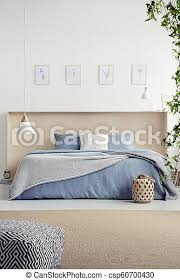 For a night lamp or books, or something like that. Pouf On Carpet In Bedroom Interior With Posters And Lamp Above Blue Bed With Blanket Real Photo Canstock