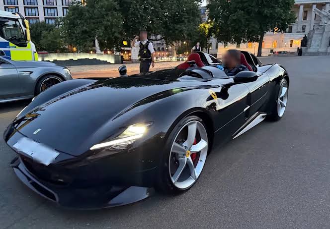 A rare Ferrari Monza SP2 being escorted by London Metropolitan Police during an enforcement operation.