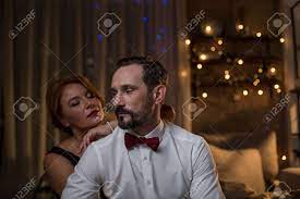 Voluptuous Middle-aged Woman Is Seducing Her Lover In Bedroom. She Is  Leaning Arm On Male Shoulders With Relaxation. Man Is Looking Aside  Pensively Stock Photo, Picture and Royalty Free Image. Image 91857696.