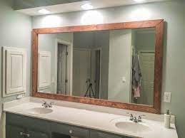 After considering some more ornate moldings or window trim, we decided a flat chunky piece of wood would be best (and it'd match the chunky shelf nearby without competing too much with other more. How To Diy Upgrade Your Bathroom Mirror With A Stained Wood Frame Building Our Rez Wood Mirror Bathroom Bathroom Mirrors Diy Bathroom Mirror Frame