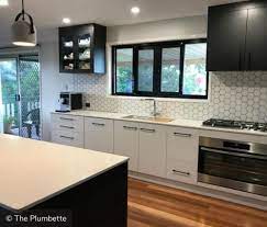 Simplicity is beauty in this monochrome kitchen with grey wooden flooring, chair cushions, lower cabinets, and dividing wall. Two Tone Kitchen Cabinets To Inspire Your Next Redesign