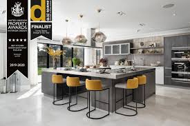 While most people don't think of utilizing black in their kitchen, the black tile wall creates stunning texture while the black counters and toe kick form striking lines to best display the golden wood drawers and doors. Award Winning Kitchen Designers Berkshire Kca