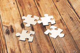The most common blank jigsaw puzzle material is wood. Group Of White Paper Jigsaw Puzzles Connected Blank Puzzle Pieces On A Wooden Background Stock Photo Picture And Royalty Free Image Image 142100143