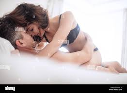 Sinnliche junge Paar Sex im Schlafzimmer. Schöne Frau in Unterwäsche auf  Mann auf dem Bett liegend Stockfotografie - Alamy