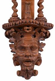 Sold at Auction: T. Boxell, Brighton, an ornately carved softwood  barometer, the base with "green man" mask, trimmed with foliate ornament,  beneath a shelf with barley twist columns flanking a thermometer with