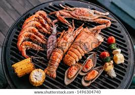 First order your live lobsters, pulled and we offer free delivery on all our seafood gift baskets, including surf and turf dinners and our bestselling boston lobster bake. Grilled Prawns Squid On Flaming Grill Seafood Bbq Stock Photos And Images Avopix Com