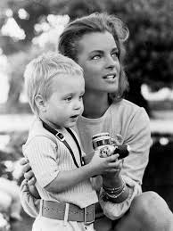 Romy Schneider jouant avec son fils David, tenant un appareil photo dans  ses mains. La photo est prise entre deux plans du film 'La Piscine' en  1968. Photo © Bridgeman Images