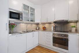 Simple chrome handles and sockets are enough to add a hint of colour. Modern White Apartment Interior Decorating Small Apartment Kitchen White Modern Kitchen Modern White Kitchen Cabinets