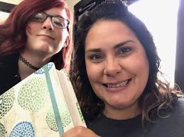 Hannah Greenwalt and Bridgette Bible are preparing bulletin boards for  junior high visitation.