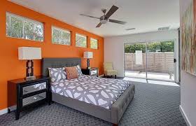 A primary bedroom with a wooden ceiling with exposed beams and orange walls, along with carpeted flooring. Master Bedroom Burnt Orange Bedroom Ideas Novocom Top