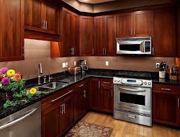Cherry Wood Kitchen Cabinets With Silver Appliances And Black Countertops Cherry Kitchen Cabinet Styles Cherry Cabinets Kitchen Cherry Wood Kitchen Cabinets