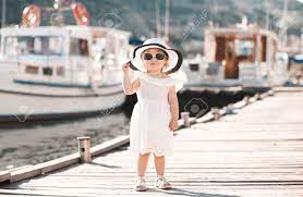 Smiling Baby Girl 1 2 Year Old Wearing White Summer Dress And Hat Walking On Wooden Pier At Sea Shore Outdoors Looking At Camera Childhood Stock Photo Picture And Royalty Free Image Image 74973185