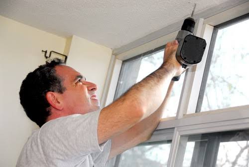 Specialist hanging thermal blackout curtains on newly fitted pole