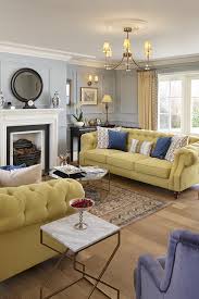 Generally, a living room is equipped with a sofa, chairs, central tables, chesterfield, a television or stereo equipment, bookshelves and other pieces of a living room is a great room to be in with a blend of decorative accents, proper furniture, colors and patterns coordination. Traditional Luxurious Living Space With Pale Yellow Chesterfield Sofas Blue Walls And Marb Yellow Living Room Decor Home Living Room Yellow Walls Living Room