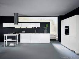 Black tolix stools sit at a white kitchen peninsula topped with a white and gray marble countertop illuminated by clear glass mini pendants. Kitchen Idea Of The Day Modern White Kitchens By Alno Ag White Modern Kitchen Kitchen Ceiling Design Modern White Kitchen Cabinets