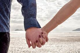 Casal apaixonado de mãos dadas na praia. [download] - Designi