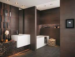 Masculine bathroom features top half of walls clad in brown grasscloth and lower half of walls clad in ivory shiplap trim lined with a tortoise shell mirror illuminated by polished nickel swing arm sconces and a black marble top washstand. 20 Masculine Bathroom Designs